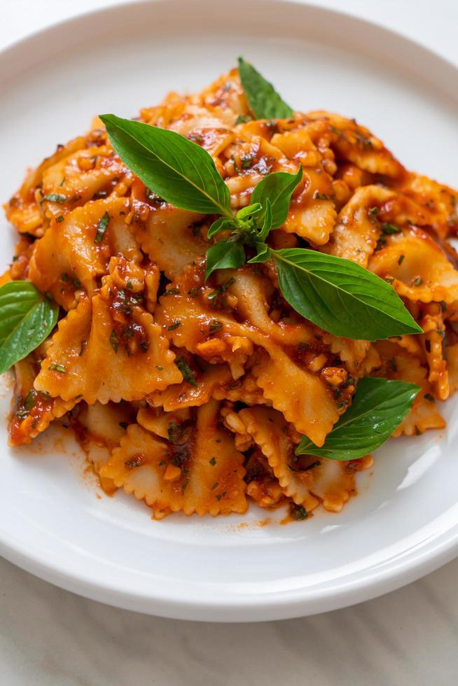 Farfalle Nudeln mit Basilikum und Knoblauch in Tomatensauce - italienische Sauce foto