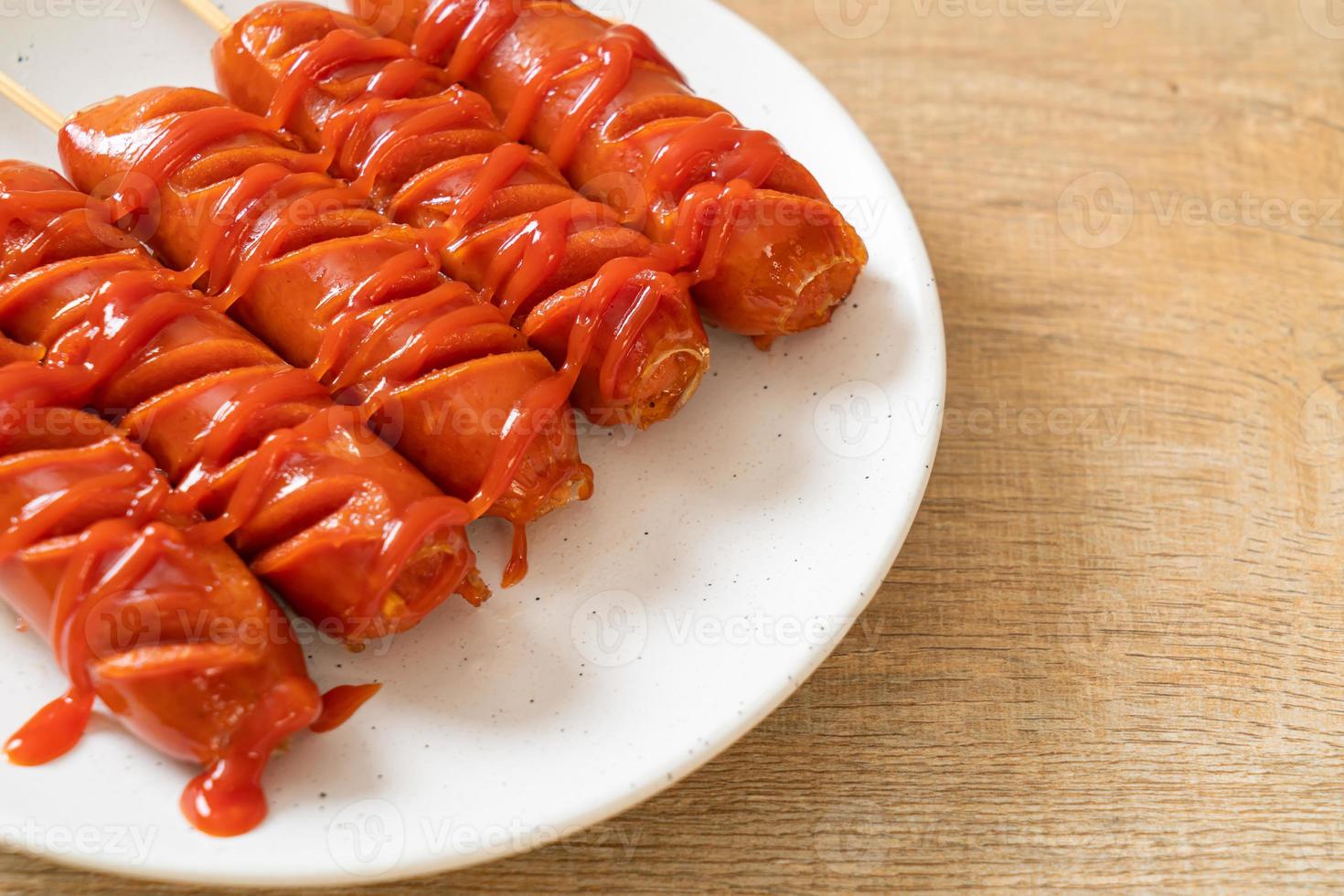 Bratwurstspieß mit Ketchup auf einem weißen Teller foto