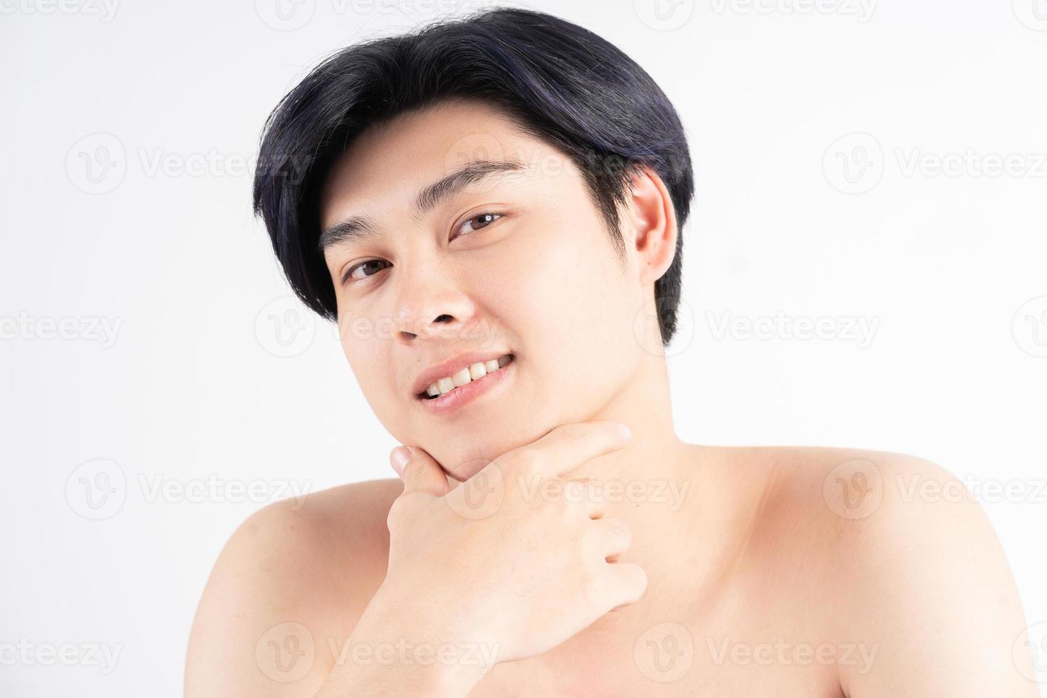 junger gutaussehender asiatischer mann auf weißem hintergrund foto