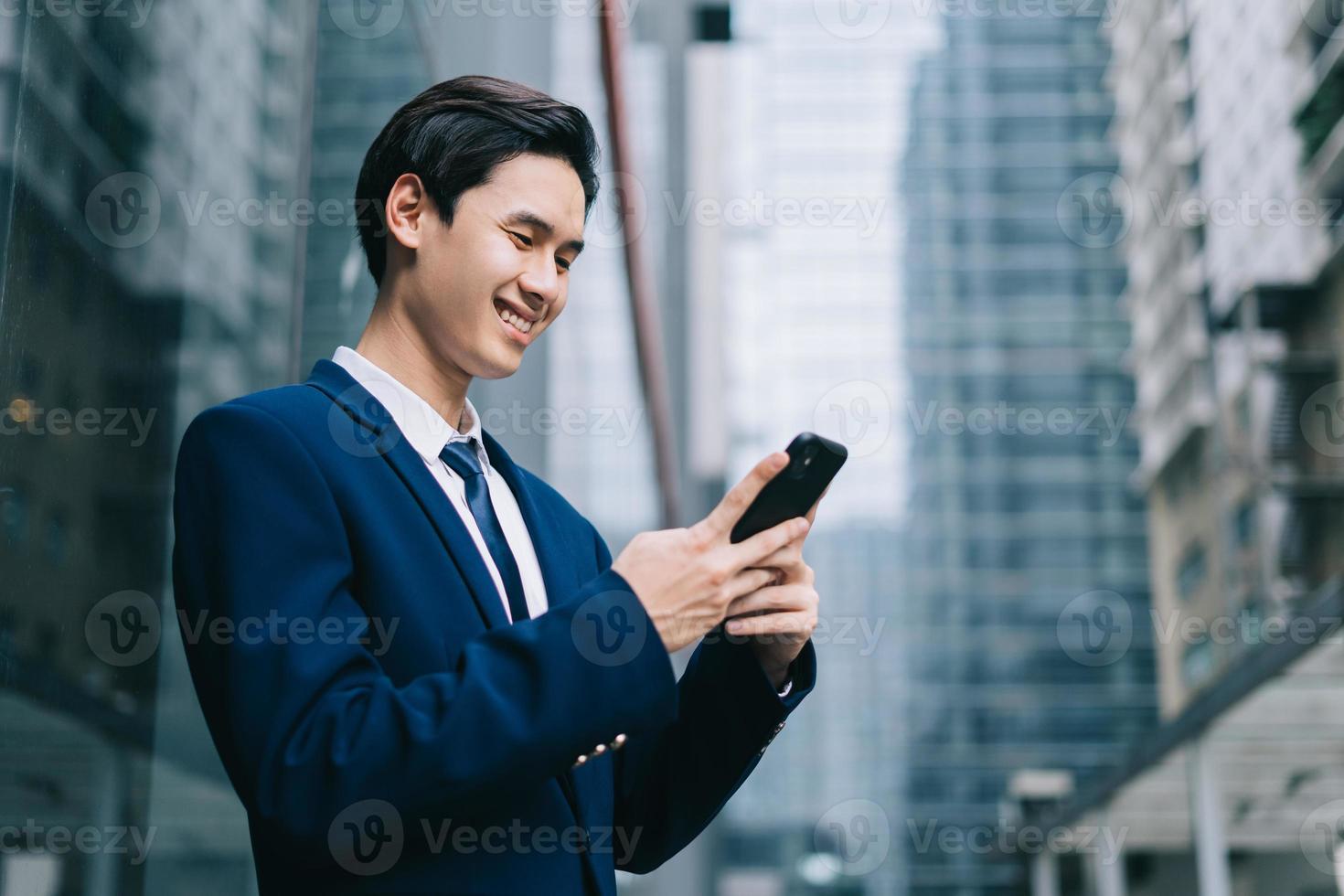 junger asiatischer Geschäftsmann mit modernem Gebäudehintergrund foto