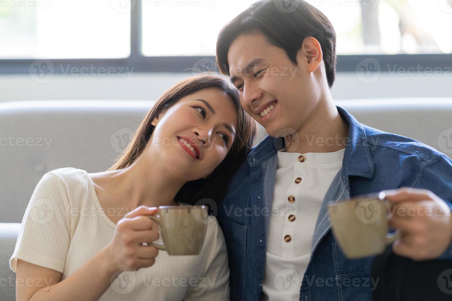 junges asiatisches paar, das sich zu hause glücklich umarmt foto
