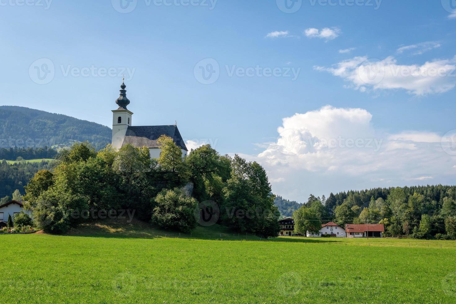 Dorf mit Kirche im Alpental bei Salzburg. Österreich foto