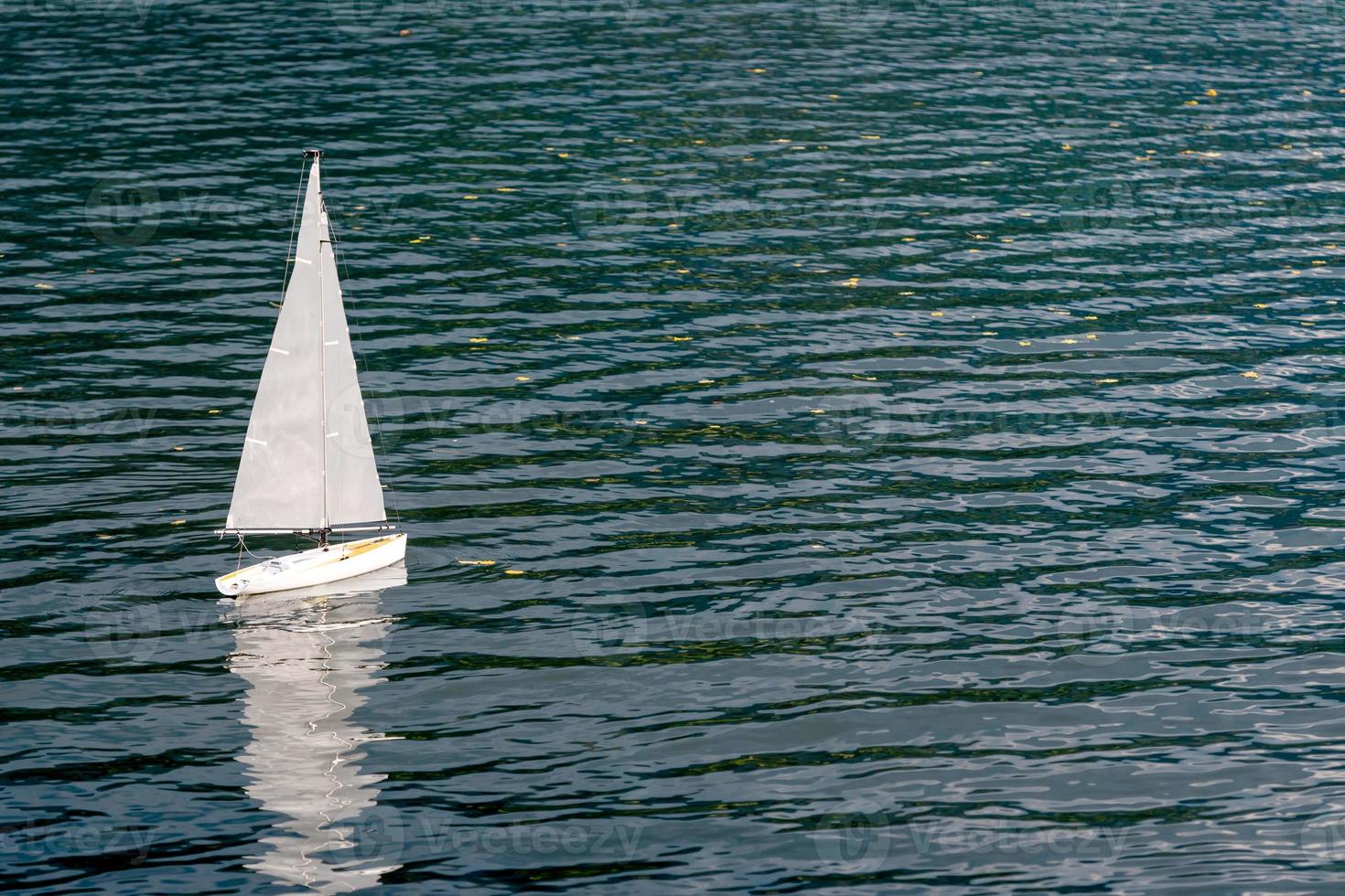 weißes Segelyachtmodell, das im See schwimmt. foto