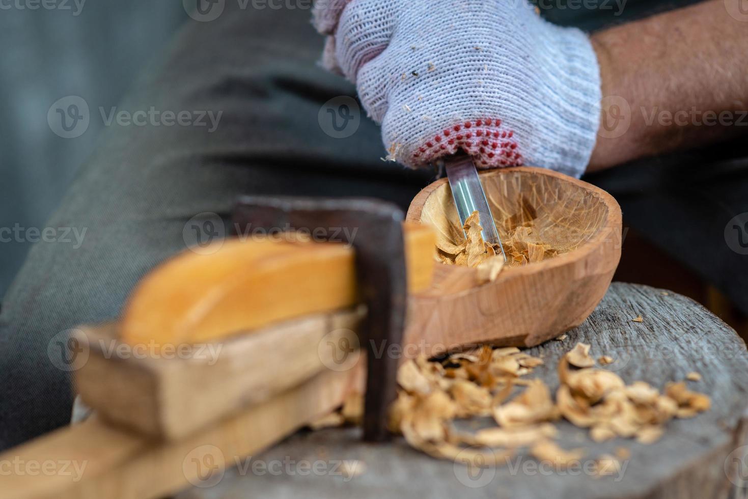 Handwerker zeigt den Prozess der Herstellung von Holzlöffeln foto