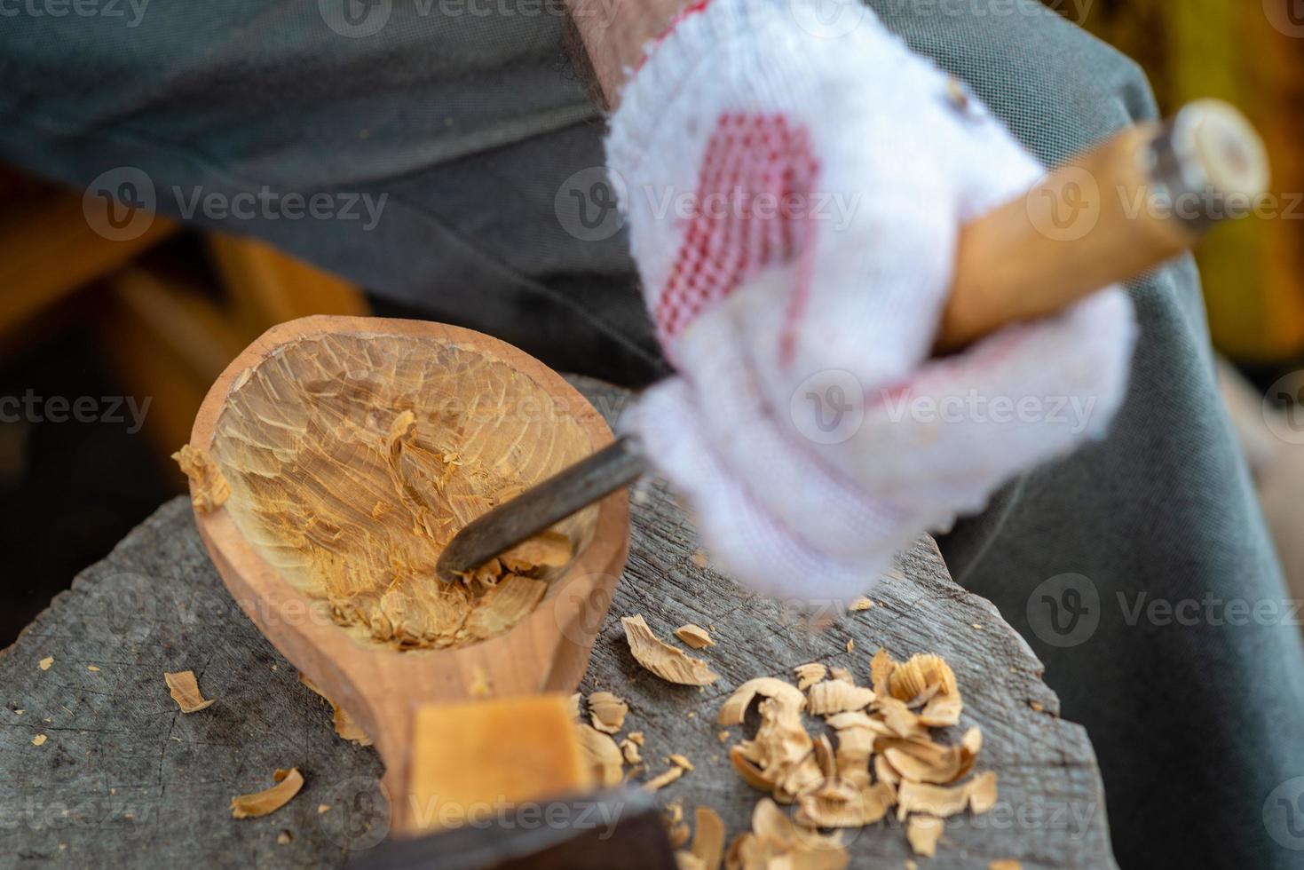 Handwerker zeigt den Prozess der Herstellung von Holzlöffeln foto