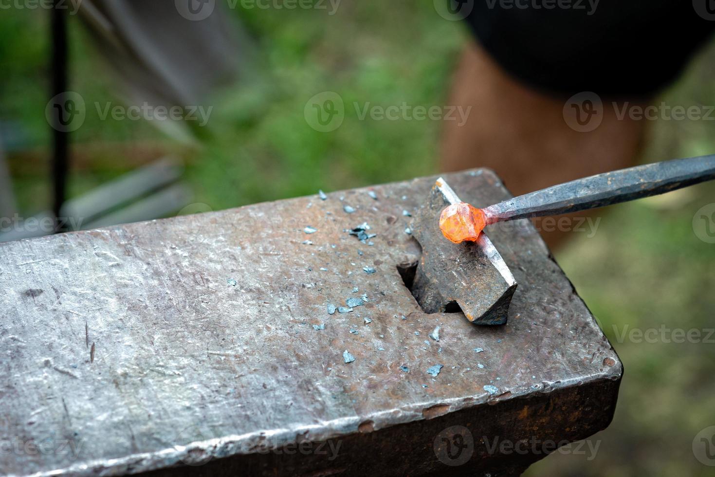 Schmied schmiedet einen Streifen aus heißem Metall foto