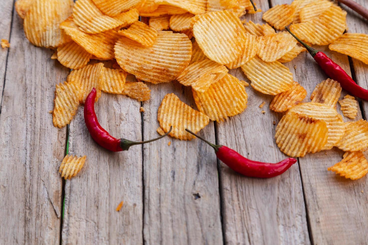 hausgemachte Paprika-Kartoffelchips auf Holztisch foto