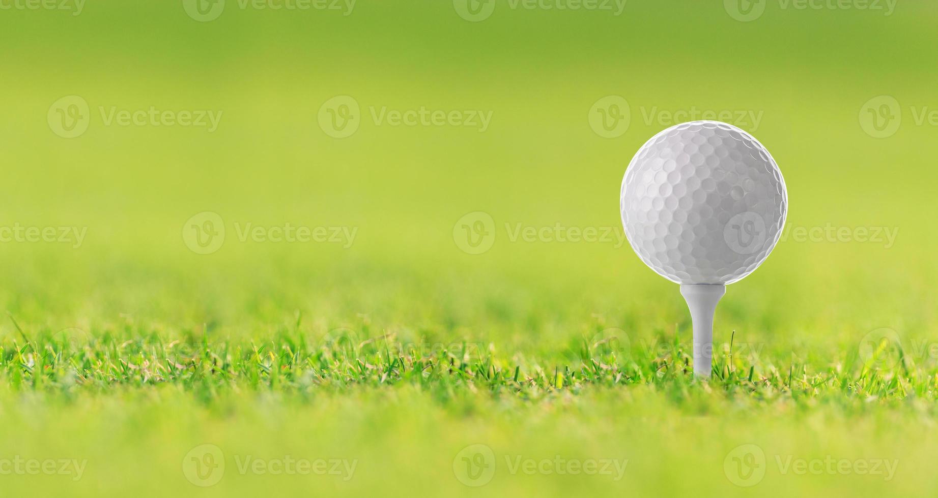 Golfball auf Tee auf grünem Gras, Golfplatz foto