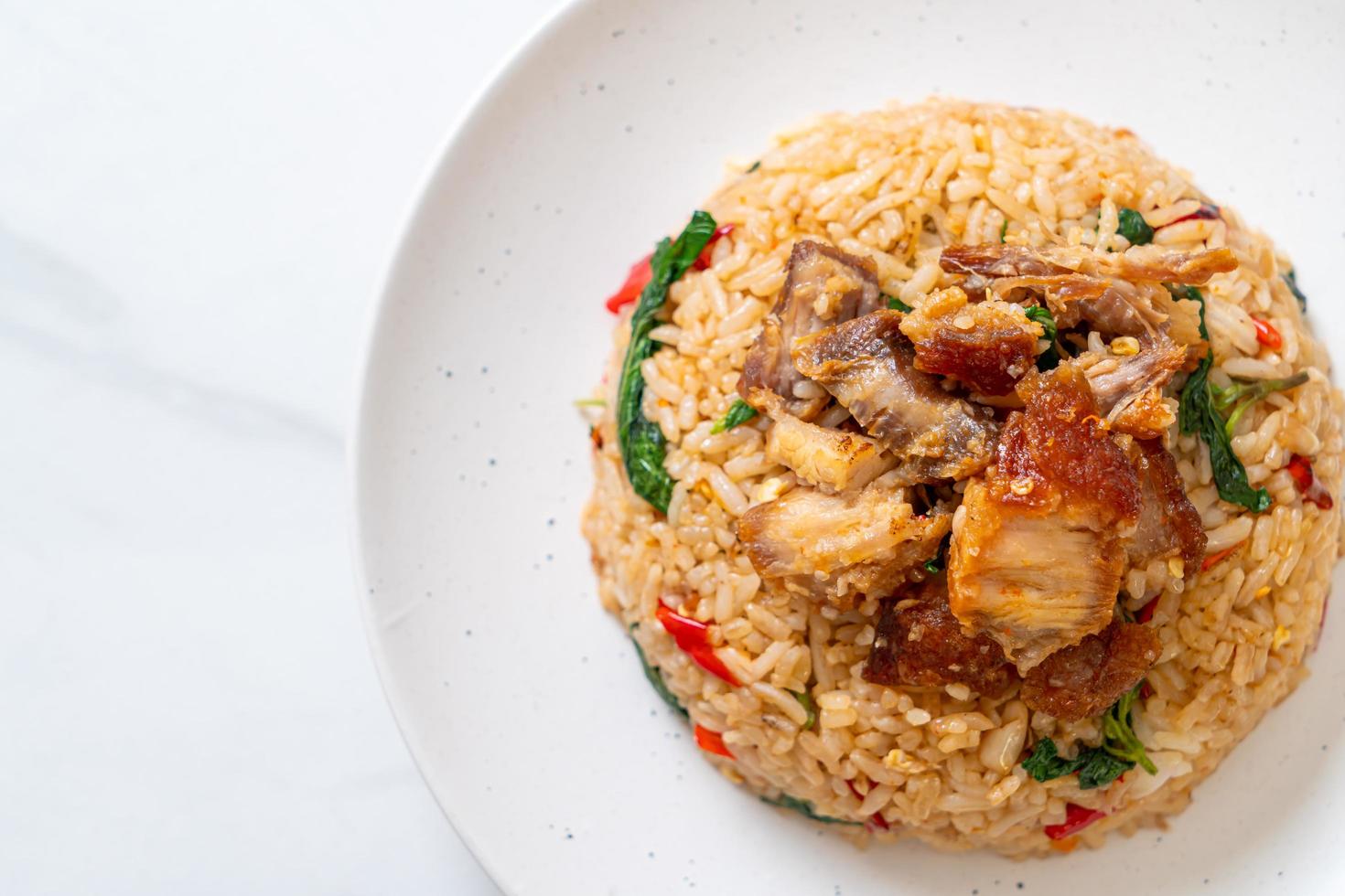 gebratener Reis mit thailändischem Basilikum und knusprigem Bauchschweinefleisch - thailändischer Art foto