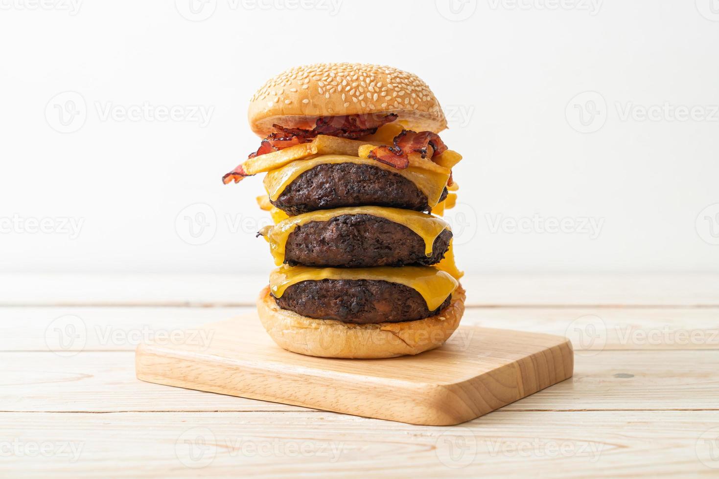Hamburger- oder Rindfleischburger mit Käse, Speck und Pommes Frites - ungesunde Art des Essens foto
