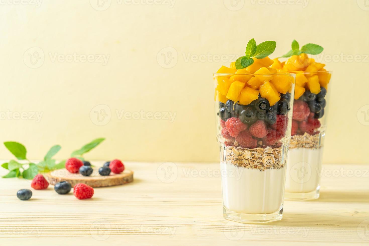 hausgemachte Mango, Himbeere und Heidelbeere mit Joghurt und Müsli - gesunder Ernährungsstil foto