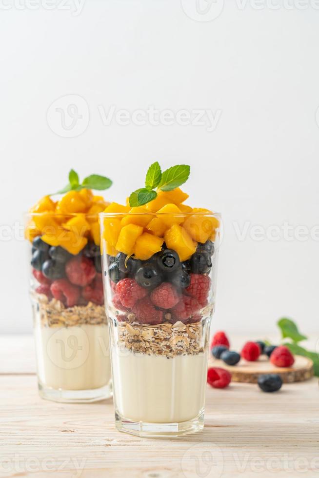 hausgemachte Mango, Himbeere und Heidelbeere mit Joghurt und Müsli - gesunder Ernährungsstil foto