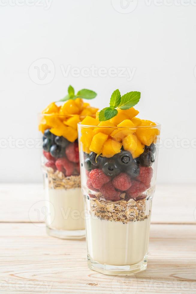 hausgemachte Mango, Himbeere und Heidelbeere mit Joghurt und Müsli - gesunder Ernährungsstil foto