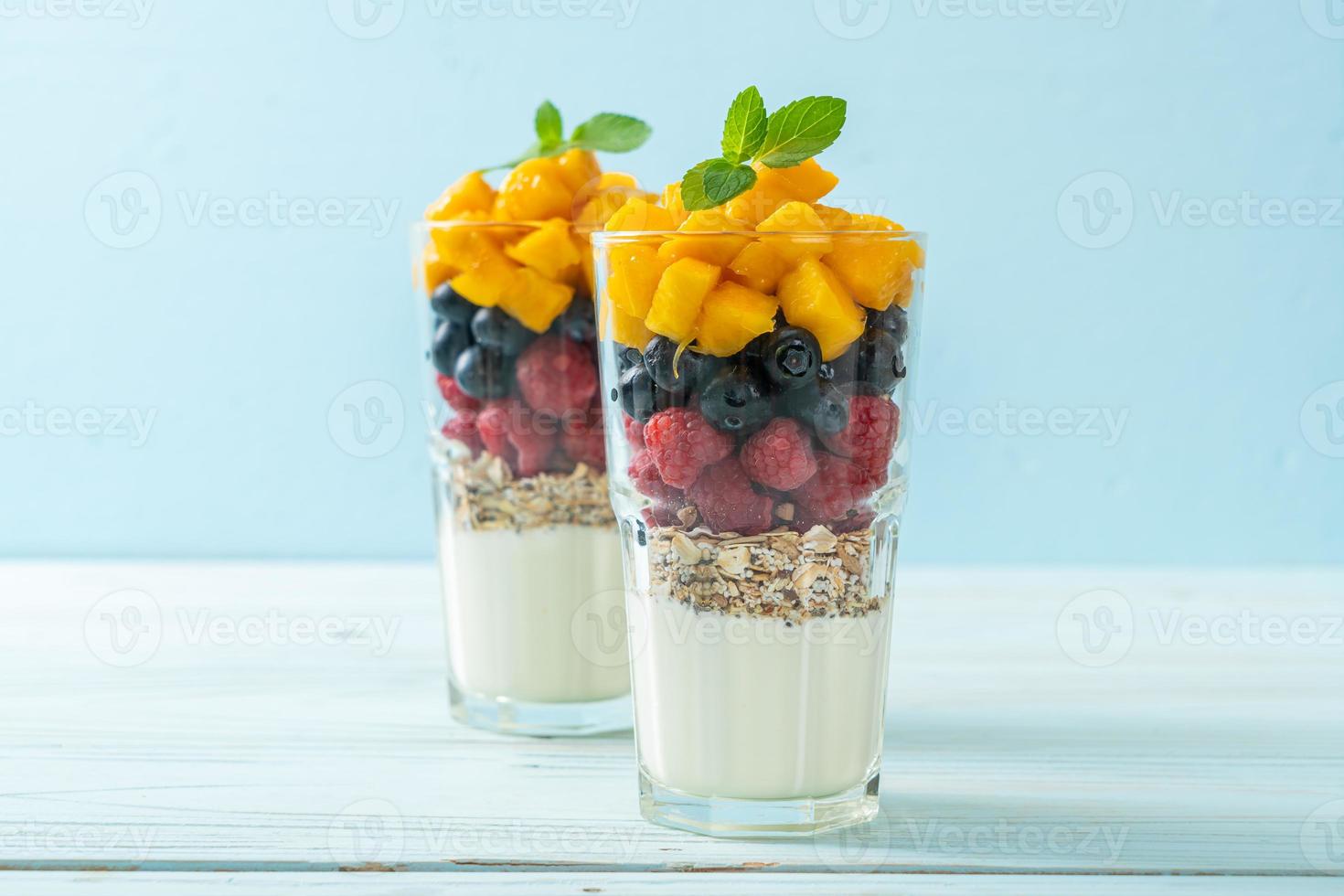 hausgemachte Mango, Himbeere und Heidelbeere mit Joghurt und Müsli - gesunder Ernährungsstil foto