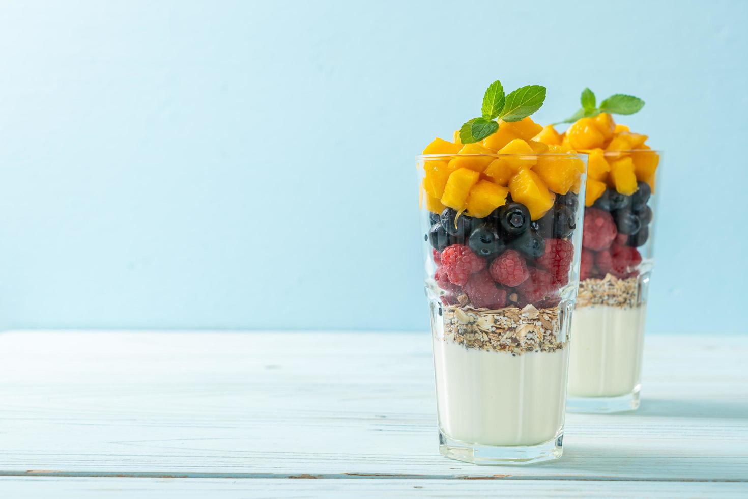 hausgemachte Mango, Himbeere und Heidelbeere mit Joghurt und Müsli - gesunder Ernährungsstil foto