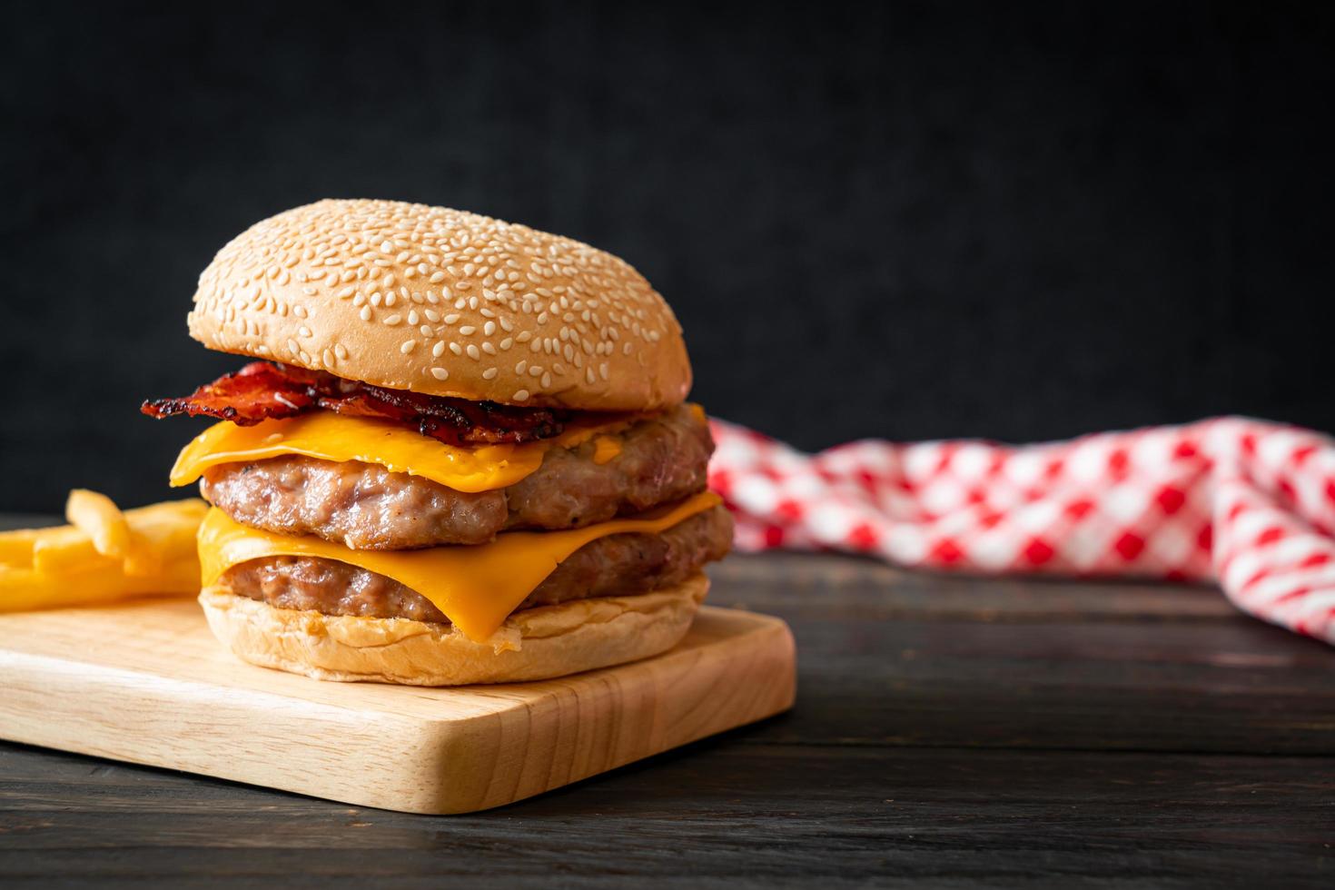 Schweinefleisch-Hamburger oder Schweinefleisch-Burger mit Käse, Speck und Pommes frites foto