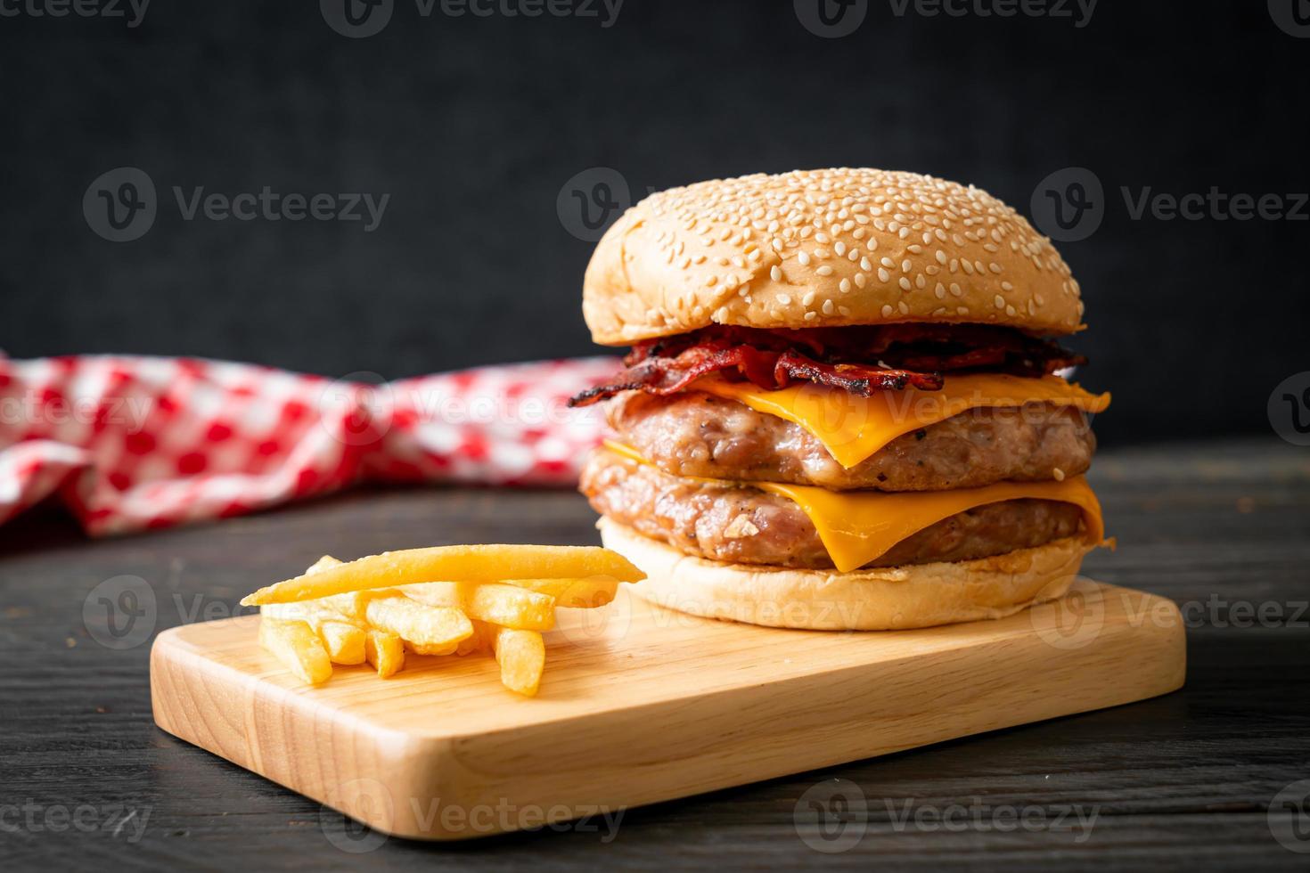 Schweinefleisch-Hamburger oder Schweinefleisch-Burger mit Käse, Speck und Pommes frites foto