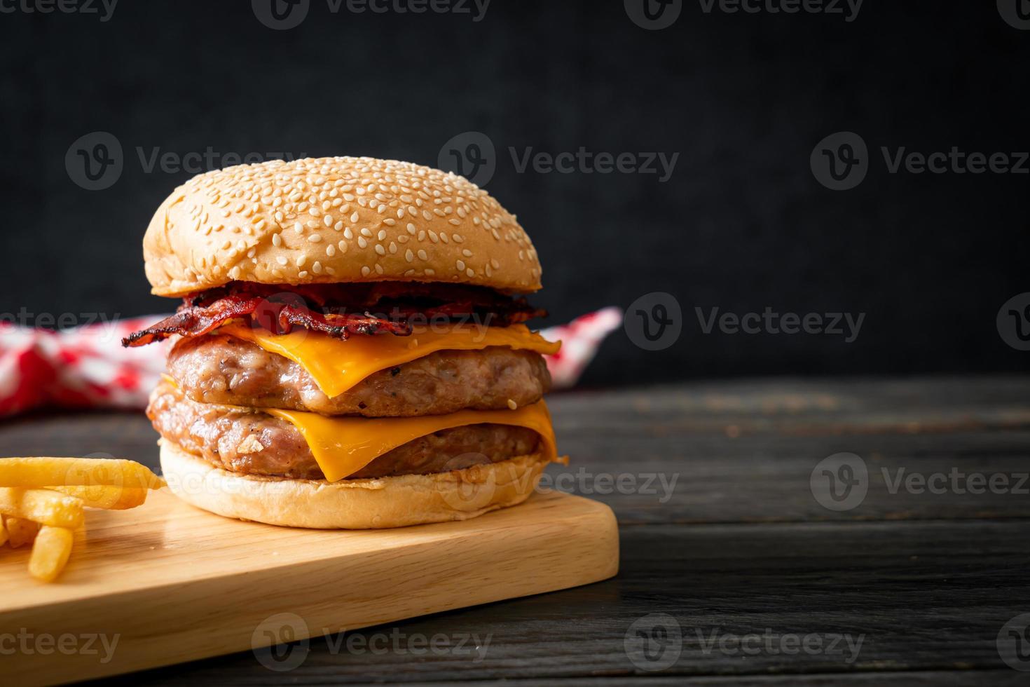 Schweinefleisch-Hamburger oder Schweinefleisch-Burger mit Käse, Speck und Pommes frites foto