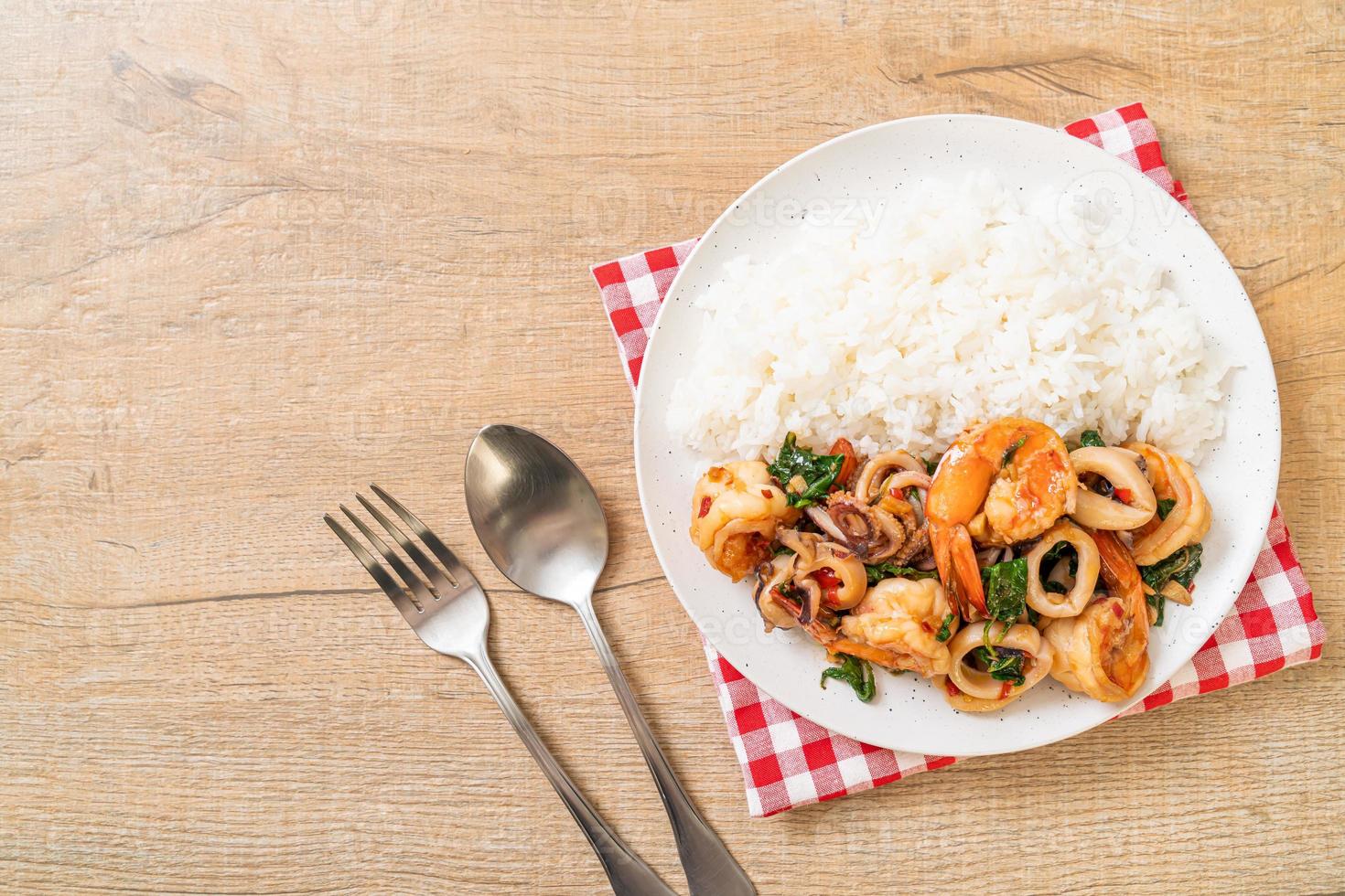 Reis und gebratene Meeresfrüchte von Garnelen und Tintenfisch mit thailändischem Basilikum - asiatische Küche foto