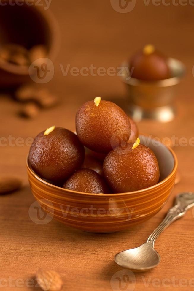 Gulab Jamun in Schüssel und antike Kupferschale mit Löffel. indisches Dessert oder süßes Gericht. foto