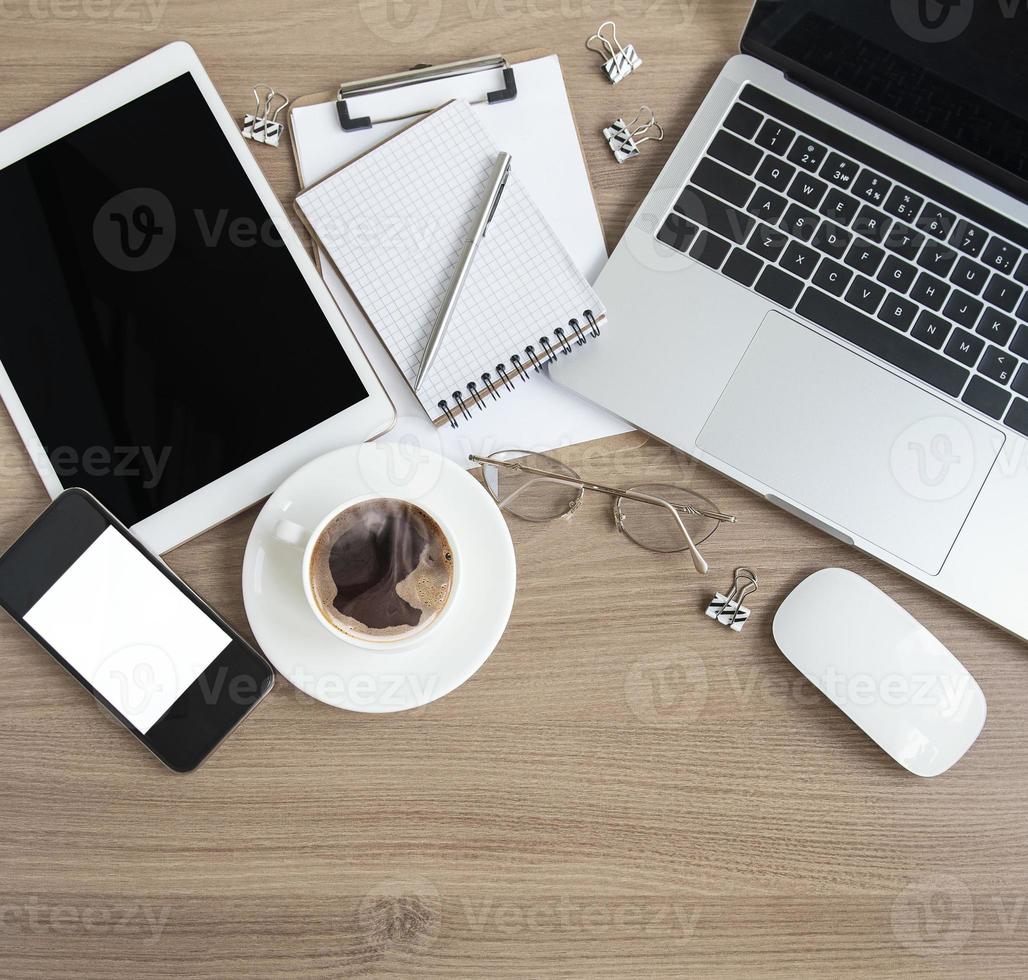 Laptop mit Bürobedarf und Kaffee auf dem Tisch. foto