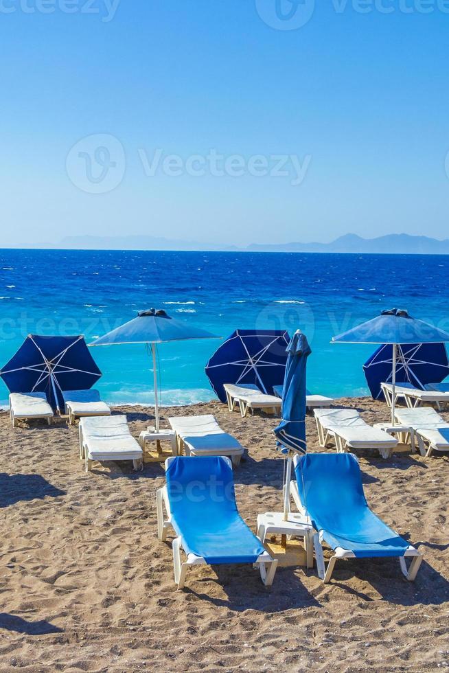 blaue Sonnenliegen am türkisfarbenen Wasser am Elli Beach auf Rhodos, Griechenland foto