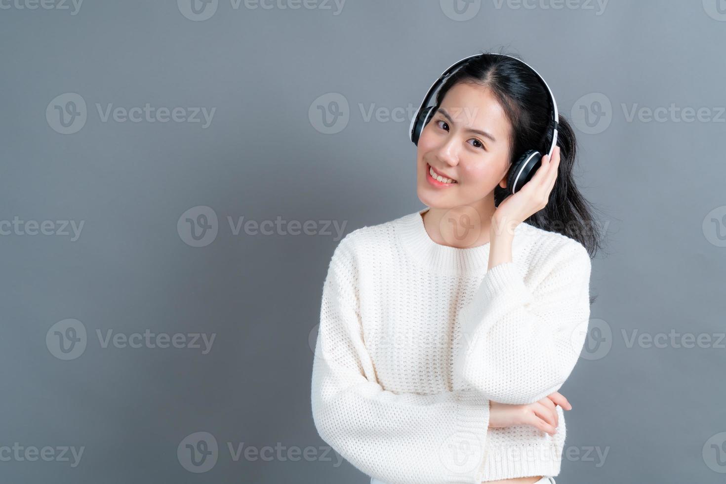 junge asiatische frau, die musik mit kopfhörern hört foto