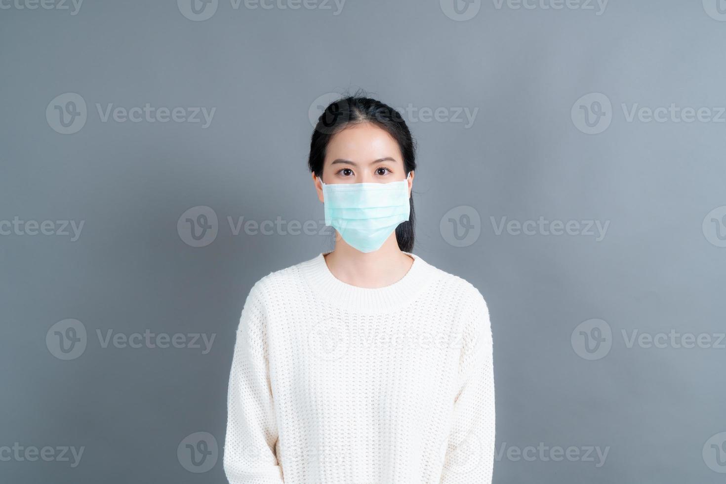 asiatische frau, die eine medizinische gesichtsmaske trägt, schützt filterstaub pm2.5 gegen verschmutzung, antismog und covid-19 foto