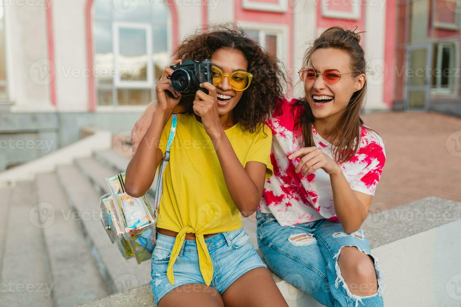 glücklich jung Mädchen freunde lächelnd Sitzung im Straße foto