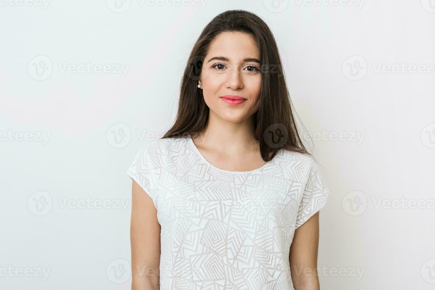 schließen oben Porträt von stilvoll jung ziemlich Frau lächelnd im Weiß T-Shirt, isoliert, natürlich sehen, lange braun Haar foto