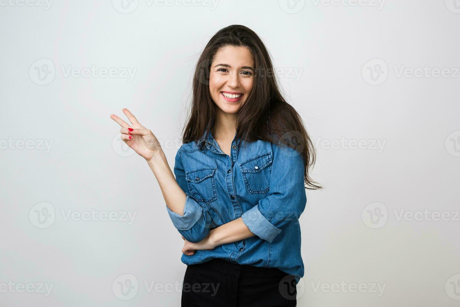 Porträt von jung ziemlich Frau lächelnd im Blau Denim Hemd auf Weiß Hintergrund, Glücklich, positiv Stimmung, isoliert, aufrichtig lächeln, lange Haar, zeigen Frieden Zeichen, positiv Stimmung foto