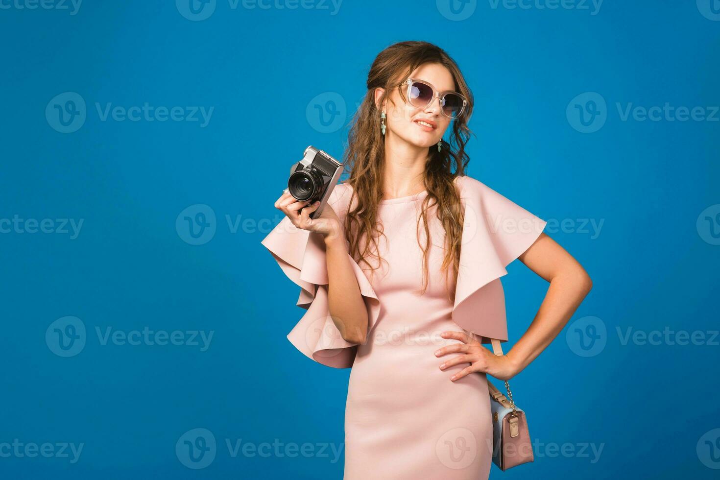 jung stilvoll sexy Frau im Rosa Luxus Kleid nehmen Bilder auf Jahrgang Kamera foto