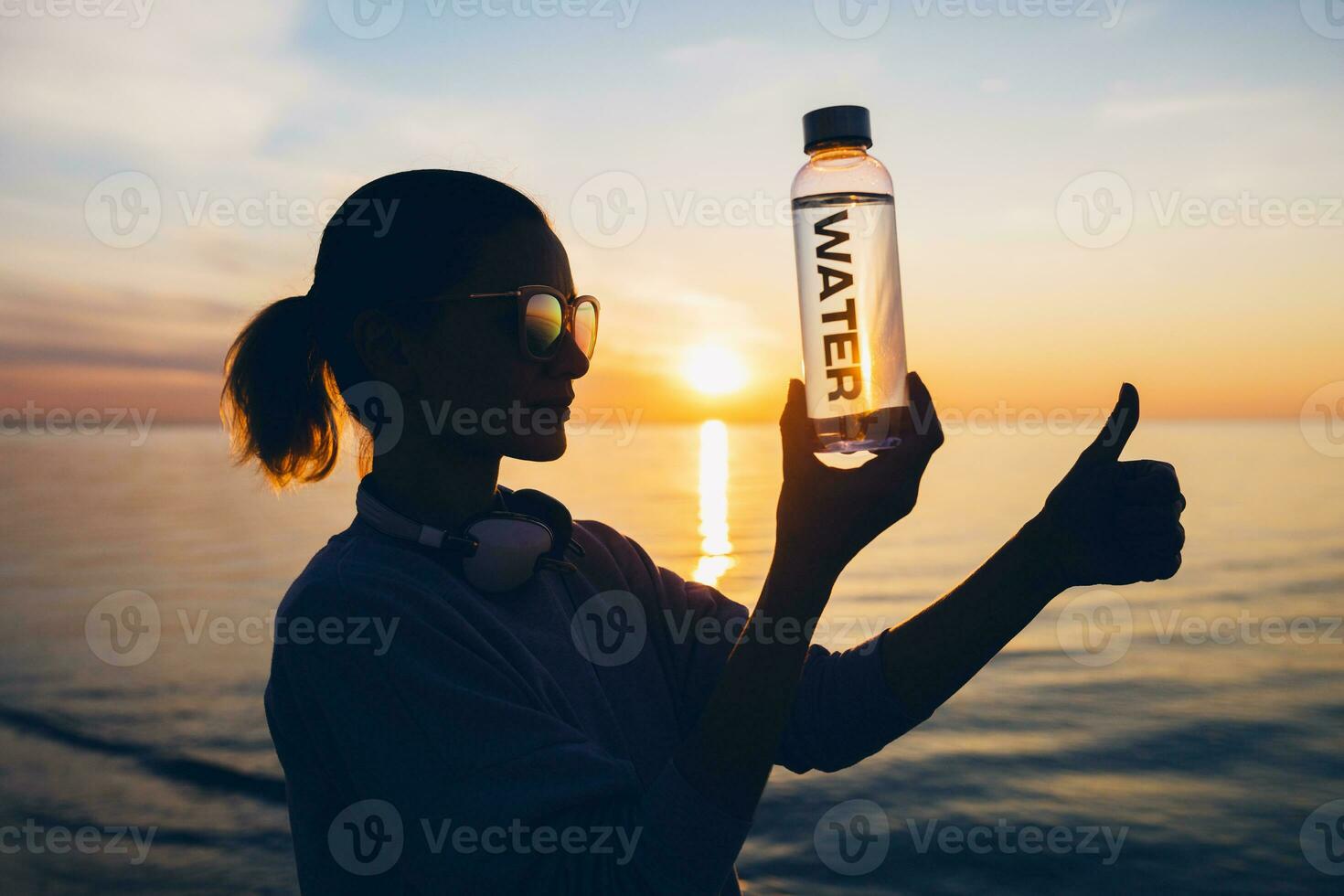 Frau beim Meer halten Flasche von Wasser foto