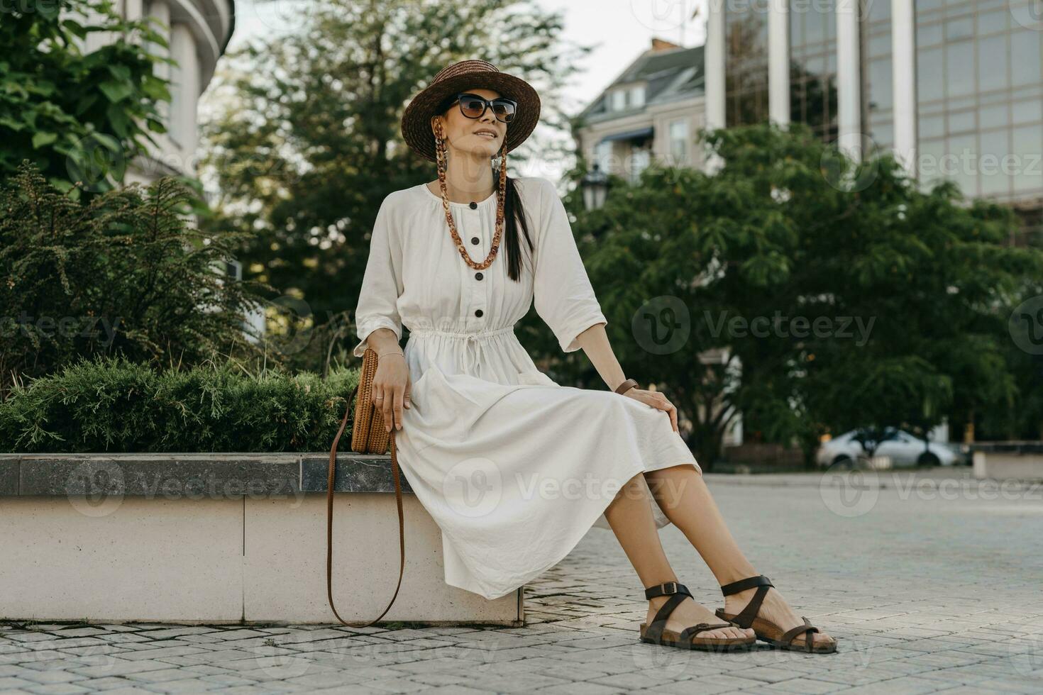 schön Frau Gehen im Straße auf Ferien gekleidet im Weiß Sommer- Mode Kleid foto