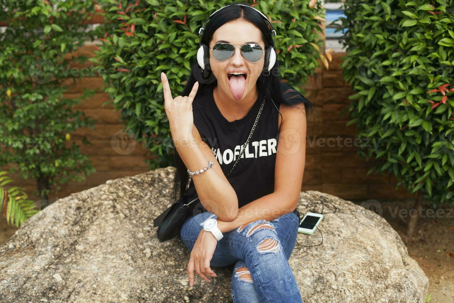 jung stilvoll Hipster Frau im schwarz T-Shirt, Jeans, Hören zu Musik- auf Kopfhörer foto