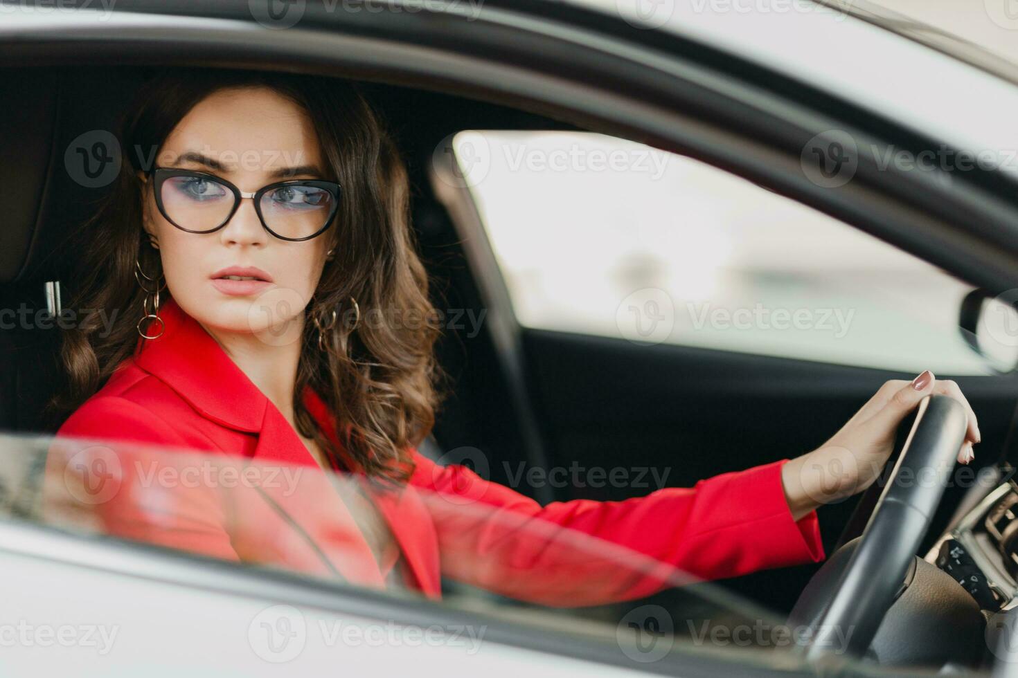 schön sexy Reich Geschäft Frau im rot passen Sitzung im Weiß Auto, tragen Brille foto