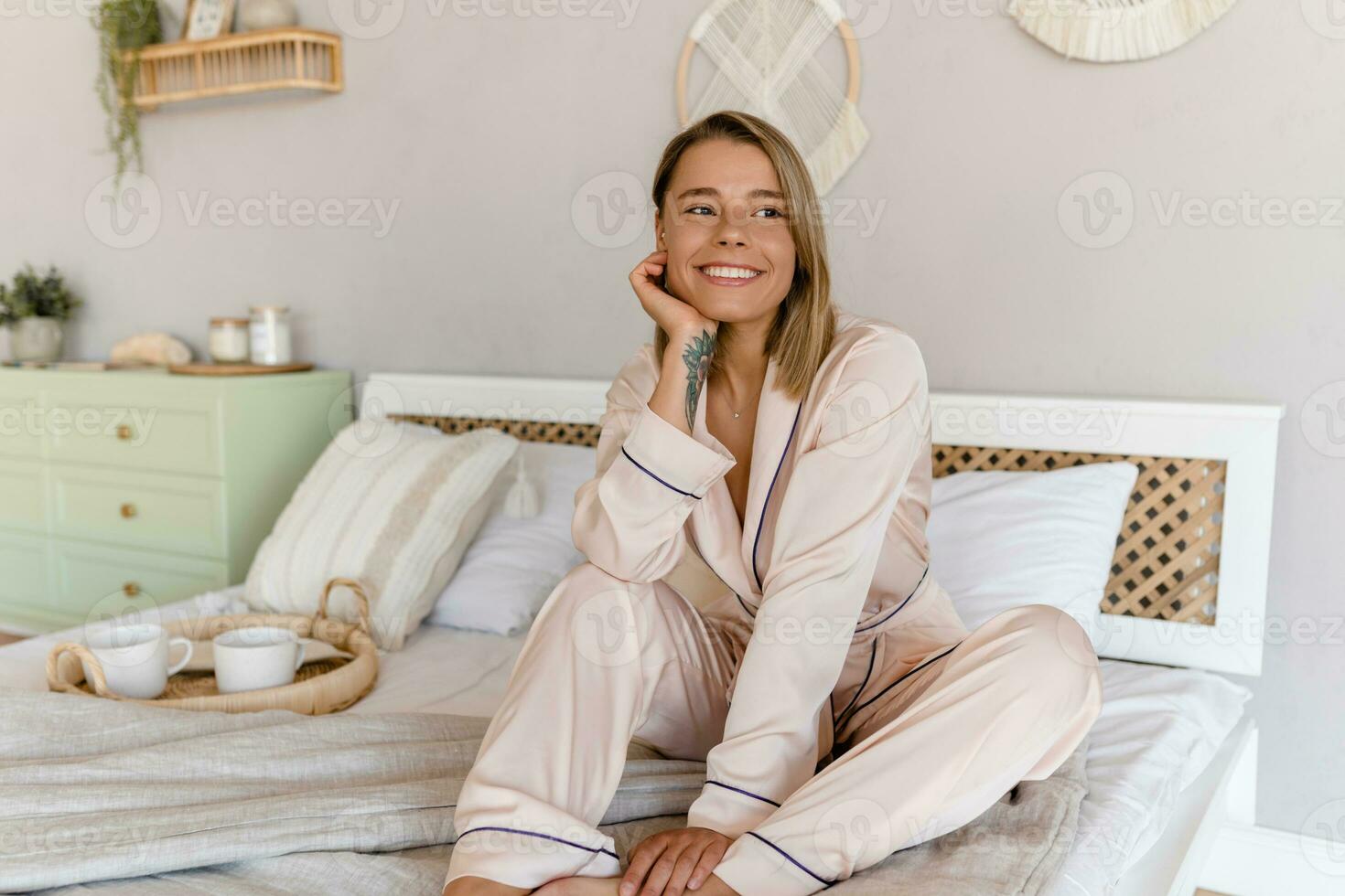 ziemlich lächelnd Frau entspannend beim Zuhause auf Bett im Morgen im Pyjama foto
