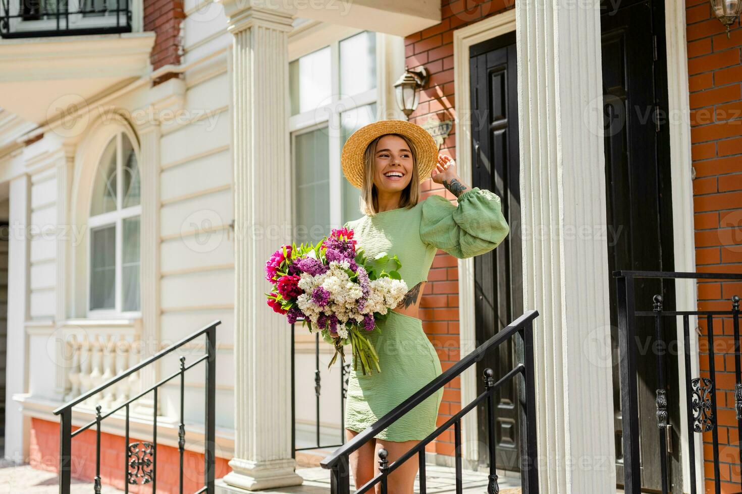 schön jung Frau im Sommer- Stil Outfit lächelnd glücklich Gehen mit Blumen im Stadt Straße foto