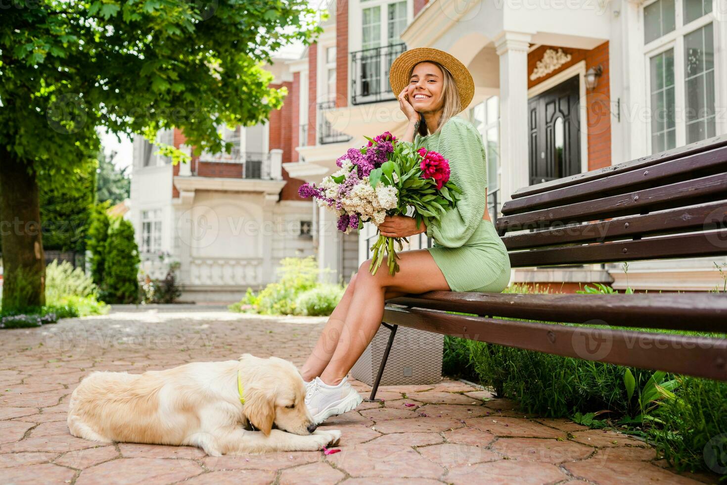 schön jung Frau im Sommer- Stil Outfit lächelnd glücklich Gehen mit Blumen und Hund foto