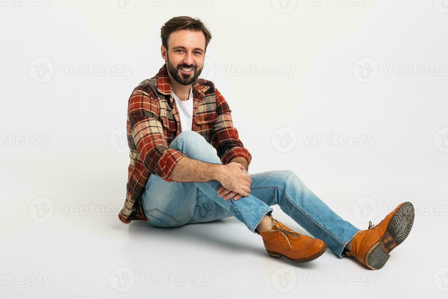 gut aussehend bärtig Mann im Hipster Outfit gekleidet im Jeans und kariert Hemd foto