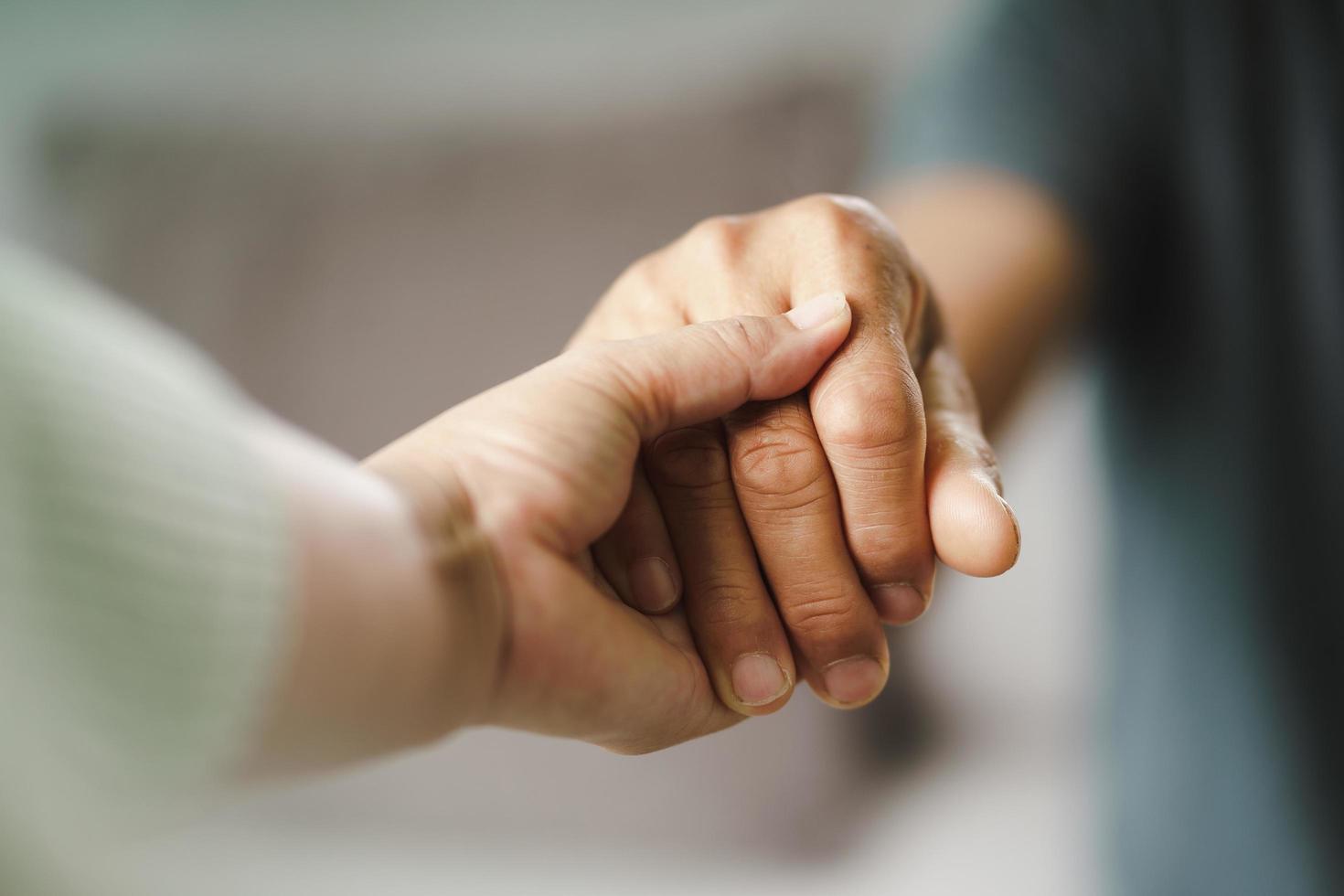 Freundinnen oder Familie, die Händchen halten, während sie einem psychisch depressiven Mann aufheitern, der Psychologe bietet dem Patienten psychische Hilfe. ptsd Konzept der psychischen Gesundheit foto