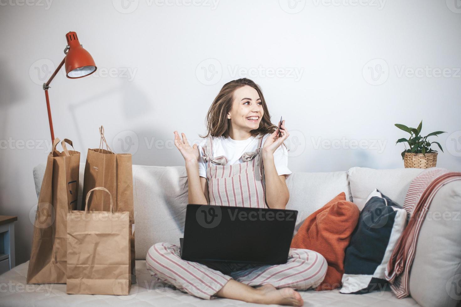 junge tausendjährige frau, die zu hause online einkauft. foto