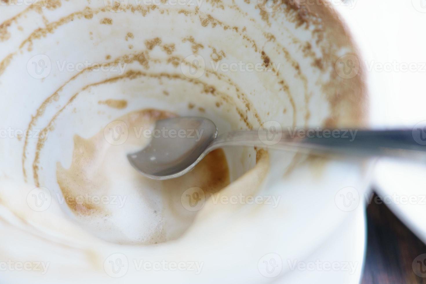 weiße Tasse mit Kaffeeresten auf dem Tisch foto