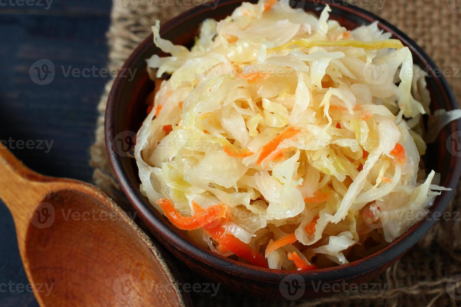 Sauerkrautsalat in einem Teller und einem Holzlöffel foto