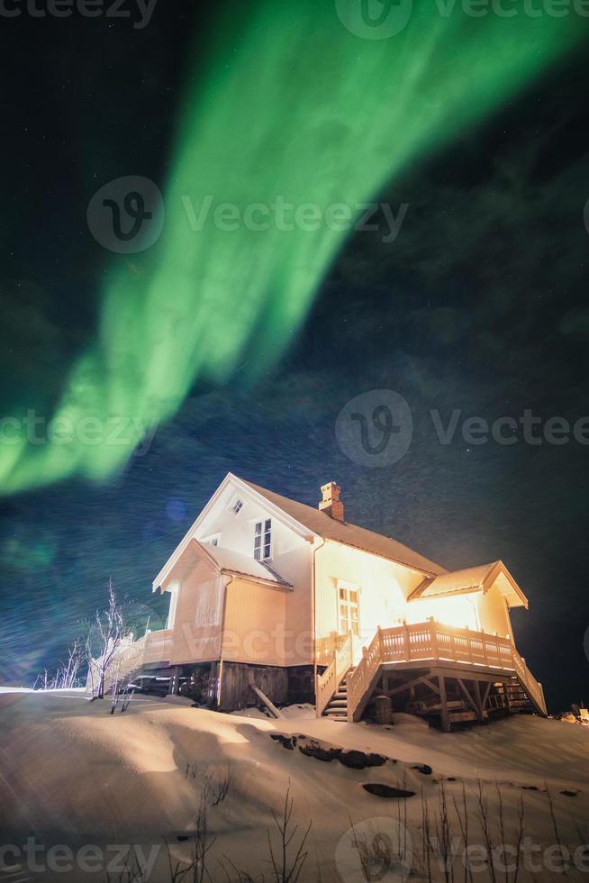 Aurora Borealis Nordlichter über weißem Haus leuchten auf Schnee foto