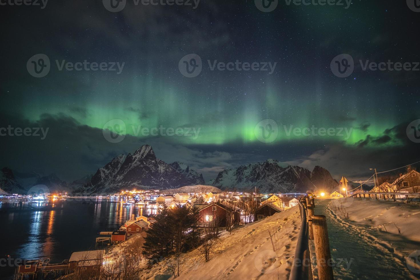 Aurora Borealis über skandinavisches Dorflicht, das im Winter scheint foto