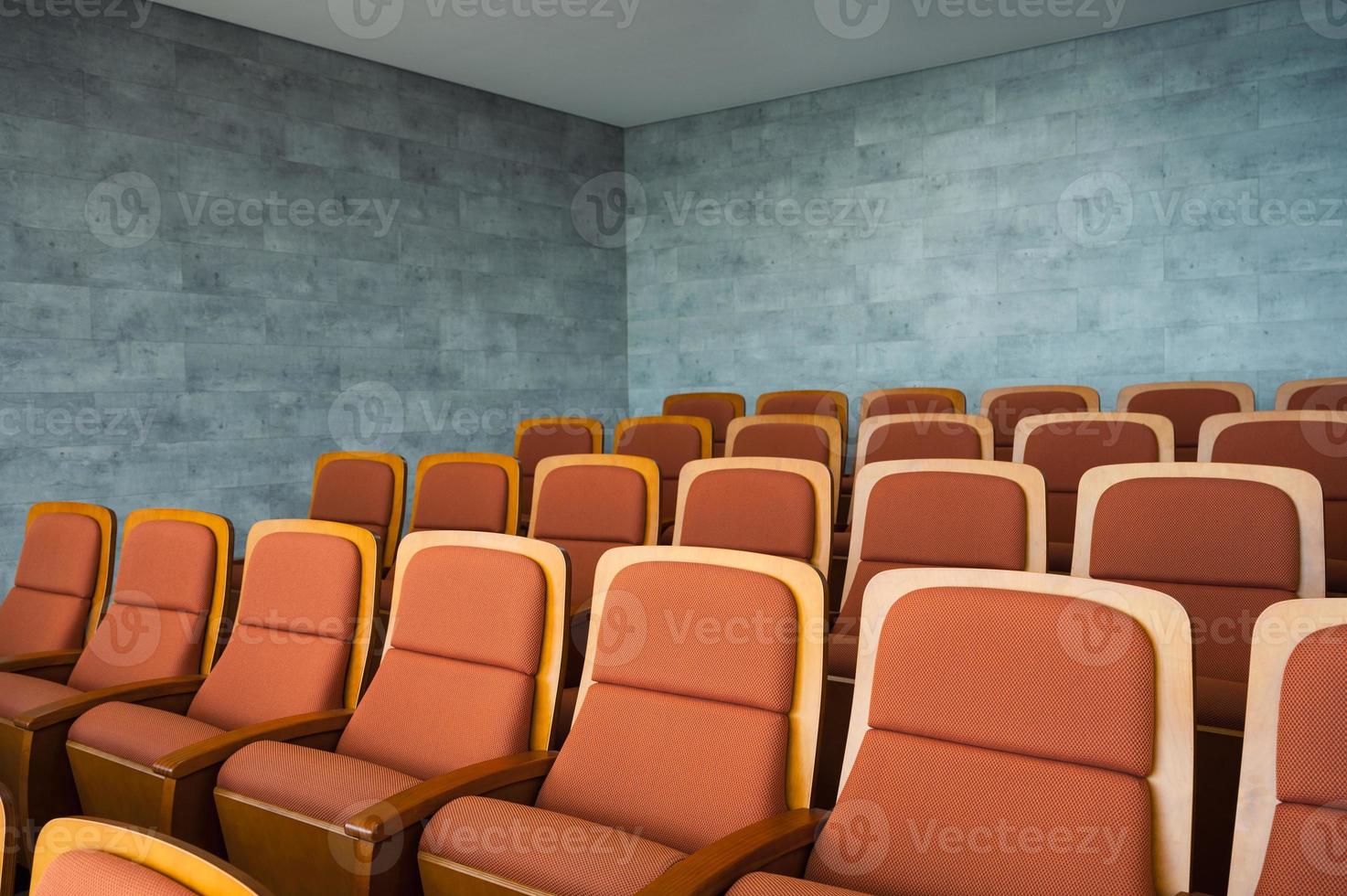 Reihe von braunen Theatersitzen und Marmorwand im Auditorium foto