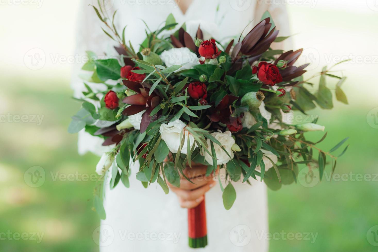 Hochzeitsstrauß aus roten Blumen und Grün foto
