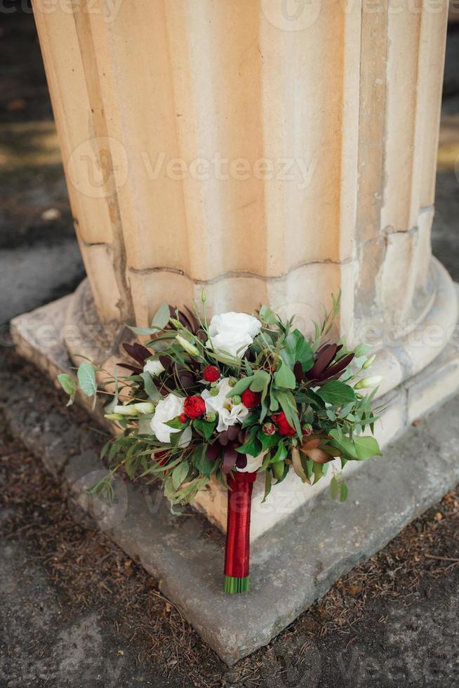 Hochzeitsstrauß aus roten Blumen und Grün foto