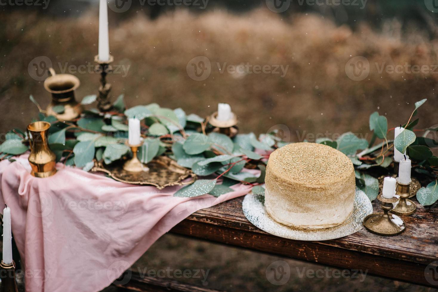 Hochzeitsdeko mit goldenem Kuchen foto